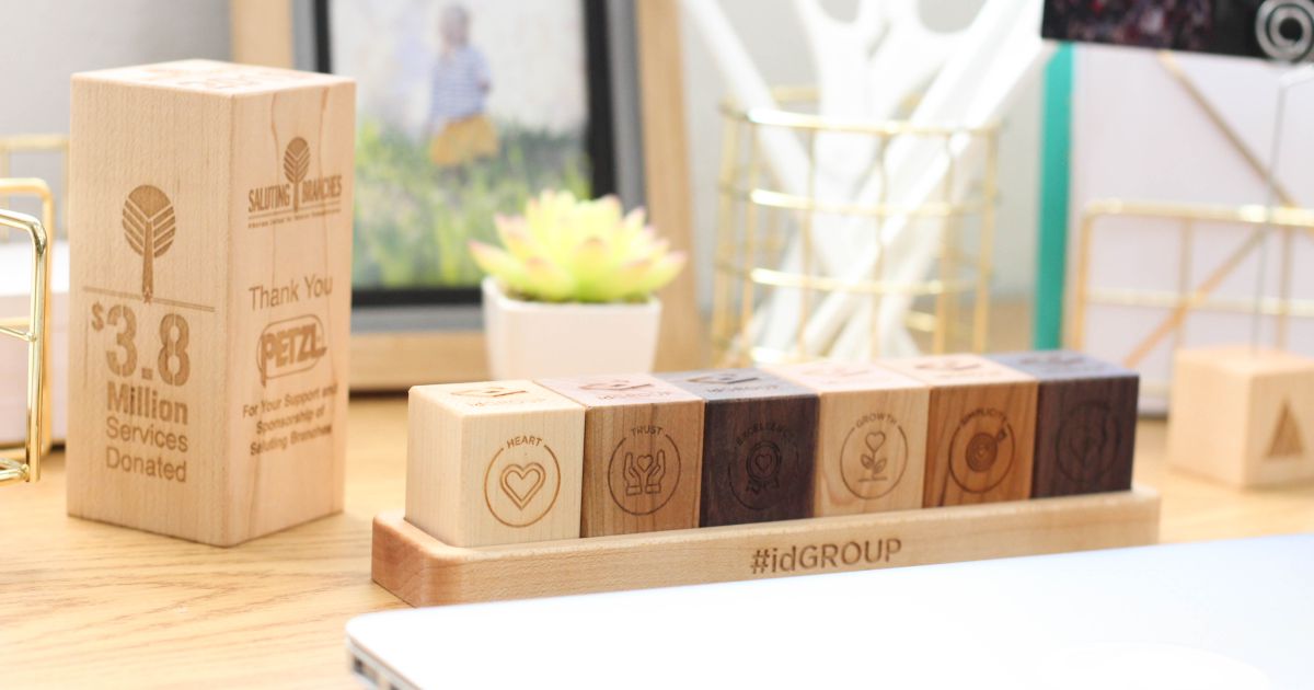 Custom engraved wooden award and personalized team value blocks on a clean office desk