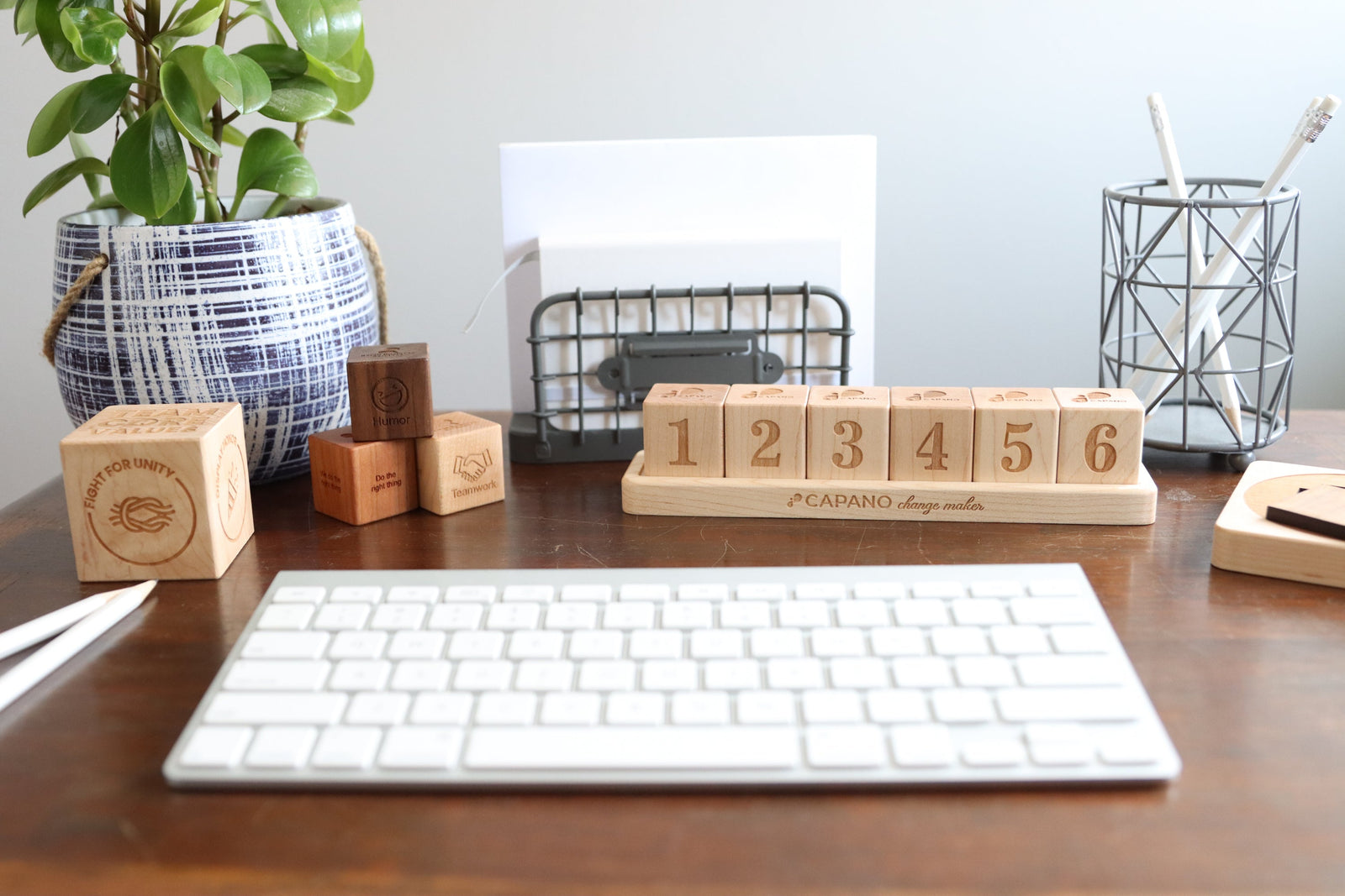 Personalized wooden welcome gifts for new employees, handcrafted in the USA and engraved with company values on a professional desk setup.